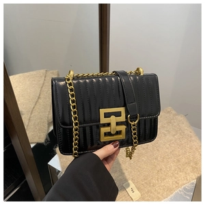 Detailed view of black quilted faux leather bag with elegant gold chain and metal lock