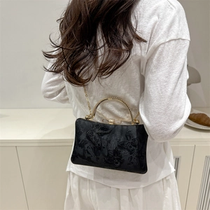 Bolso de fiesta negro con bordado de mariposas y asa dorada con diseño de lazo elegante