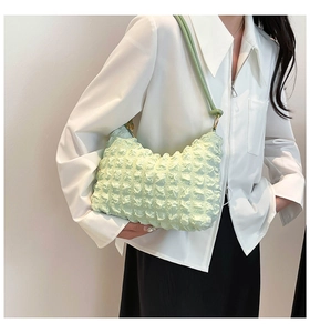 Detail of mint green pleated puffy shoulder bag with soft textured grid pattern