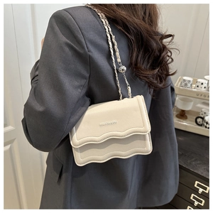 Detail of off-white crossbody bag with wavy flap design and metal chain strap