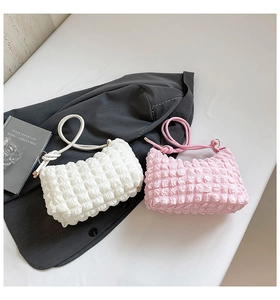 Detail of soft bubble texture on stylish white and pink pleated shoulder bags