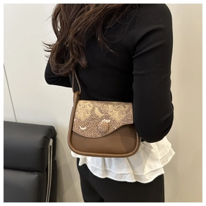 Close-up of brown butterfly shoulder bag with gold cloud pattern on a female model