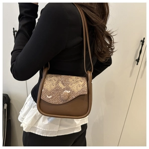 Brown crossbody bag with traditional cloud jacquard detail shown on model's side