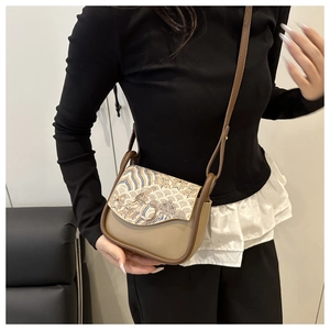 Detail of saddle bag featuring traditional Chinese embroidery and adjustable leather strap