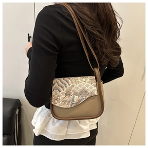 Detail of crossbody bag featuring traditional Chinese embroidery and leather strap