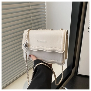 Close-up of creamy white litchi pattern leather crossbody bag with wavy flap design