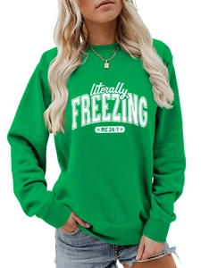 Detail of green crewneck sweatshirt with white literally freezing text and ribbed cuffs