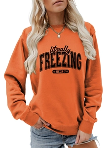 Detail of orange sweatshirt featuring literally FREEZING text and ribbed cuffs
