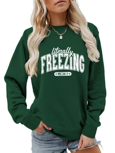 Close-up of white 'literally FREEZING' print on deep green long sleeve sweatshirt fabric