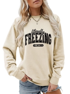 Detail of cream sweatshirt featuring literally FREEZING ME 24:7 text and snowflake print