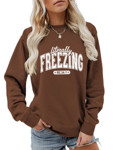 Close-up of literally freezing me 24:7 white text print on a brown oversized sweatshirt