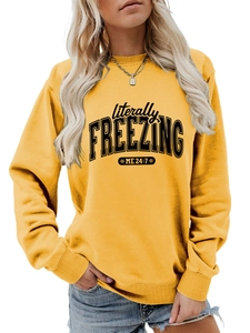 Detail of 'literally FREEZING ME 24:7' black print on a bright yellow crewneck sweatshirt