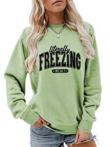 Detail of sage green crewneck sweatshirt with black 'literally FREEZING' text print