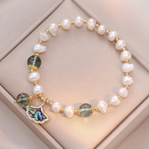Elegant baroque pearl bracelet with green gemstones and a ginkgo leaf shell pendant