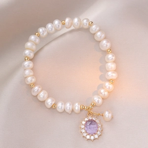 Freshwater pearl bracelet with purple zircon pendant and golden accents on silk
