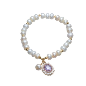 Elegant freshwater pearl bracelet with purple zircon pendant and golden accents on white background