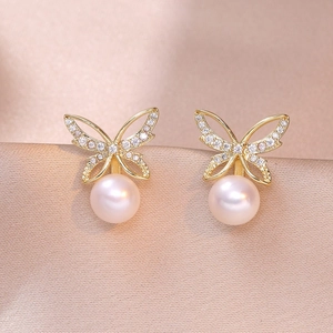 Elegant gold butterfly earrings with sparkling cubic zirconia and white pearls on silk