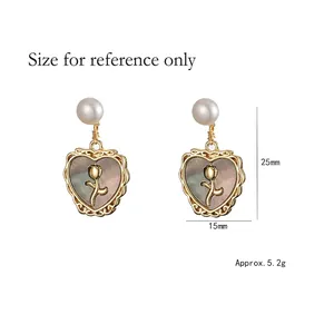 Elegant heart-shaped pearl earrings with gold floral relief and iridescent shell inlay