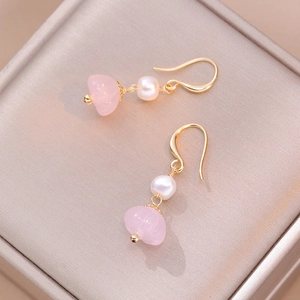 Vintage freshwater pearl and pink crystal flower dangle earrings on a jewelry box display
