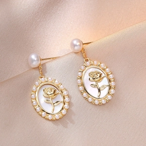 French vintage rose earrings with freshwater pearl inlays on champagne silk fabric