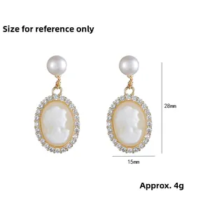 Vintage gold drop earrings with freshwater pearls and cameo portraits on white background