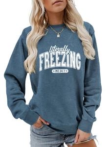 Close-up of snowflake print and text on women's loose blue crewneck sweatshirt