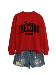Detail view of red 'literally FREEZING' sweatshirt paired with ripped denim shorts