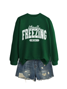 Flat lay of green 'literally freezing' sweatshirt paired with distressed denim shorts