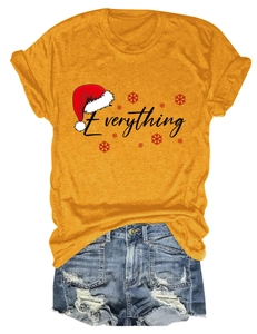 Close-up of yellow Everything Christmas T-shirt paired with distressed denim shorts
