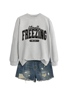 Detail of grey sweatshirt with 'literally FREEZING' text and blue denim shorts set
