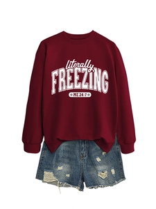 Detail of burgundy sweatshirt with white text print and distressed denim shorts set