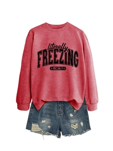 Detail of the black literally freezing typography on the brick red oversized sweatshirt