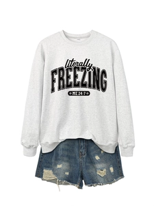Detail of grey sweatshirt with literally FREEZING ME 24:7 print and snowflake design