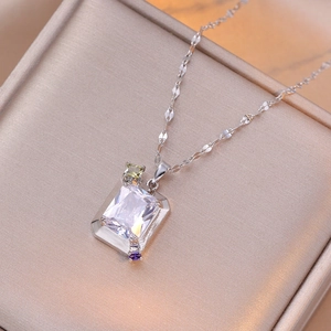 Collier élégant en acier titane avec pendentif en zircon coloré sur satin champagne