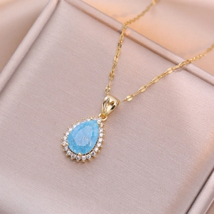 Elegant gold water-drop necklace with light blue stone and zircon halo in a velvet gift box
