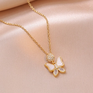 Elegant gold butterfly necklace with zircon and shell wings on soft silk background