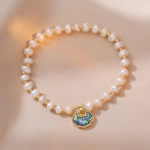 Elegant freshwater pearl bracelet with golden lock pendant on champagne silk background