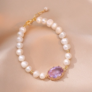 Elegant gold bracelet with freshwater pearls and a large oval purple zircon centerpiece