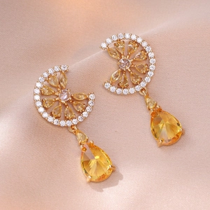 Élégantes boucles d'oreilles dorées en cristal jaune citron sur tissu de soie
