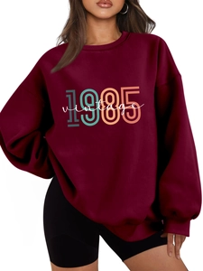 Detail of burgundy oversized sweatshirt with 1985 vintage print and cotton texture