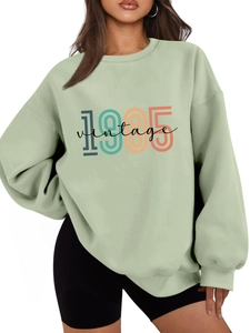 Close-up of mint green vintage 1985 printed sweatshirt with thick warm fabric