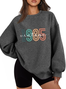 Detail view of the 1985 vintage print on a dark gray thick autumn sweatshirt