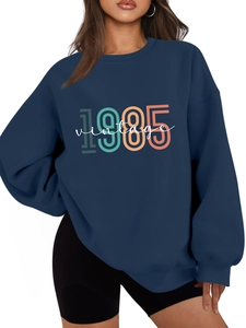 Close-up of navy blue 1985 vintage sweatshirt with retro letter print and ribbed cuffs