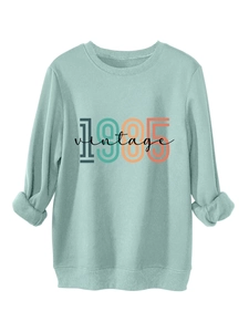 Detail of mint green vintage 1985 sweatshirt showing cotton texture and folded cuffs