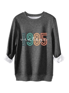 Detail of dark grey fleece sweatshirt featuring 1985 vintage print and warm lining