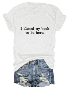 Détail à plat d'un t-shirt blanc avec le slogan 'I closed my book to be here' imprimé