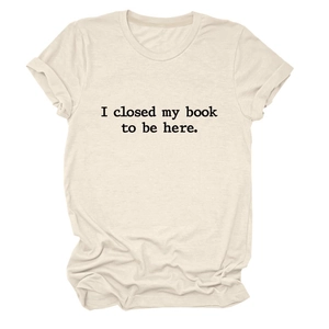 Détail d'un t-shirt beige en coton avec inscription I closed my book to be here