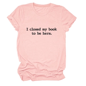 Détail du t-shirt en coton rose clair avec inscription I closed my book to be here imprimée