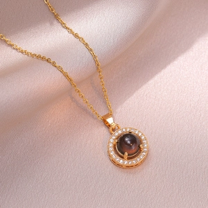 Collana con pendente a fiore dorato con alone di zirconi e pietra centrale su seta