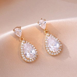Elegant gold-plated waterdrop earrings with clear cubic zirconia on pink silk fabric